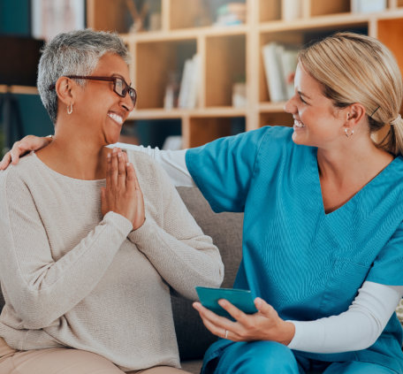 caregiver laughing together with a woman