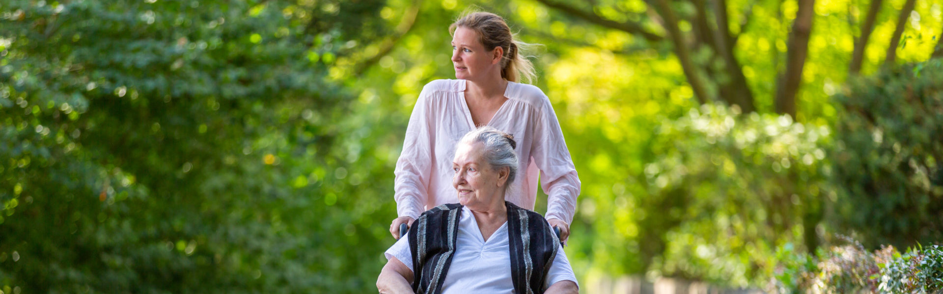 woman strolling along at the park with her elderly mother