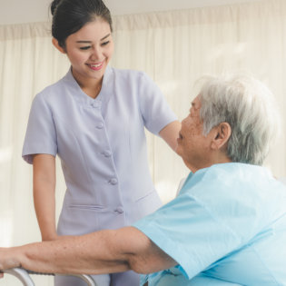 female caregiver and an elderly woman looking at each other