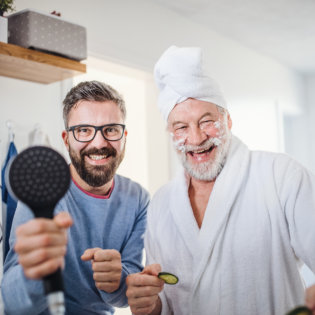 A male caregiver helping an elderly man in his bathing