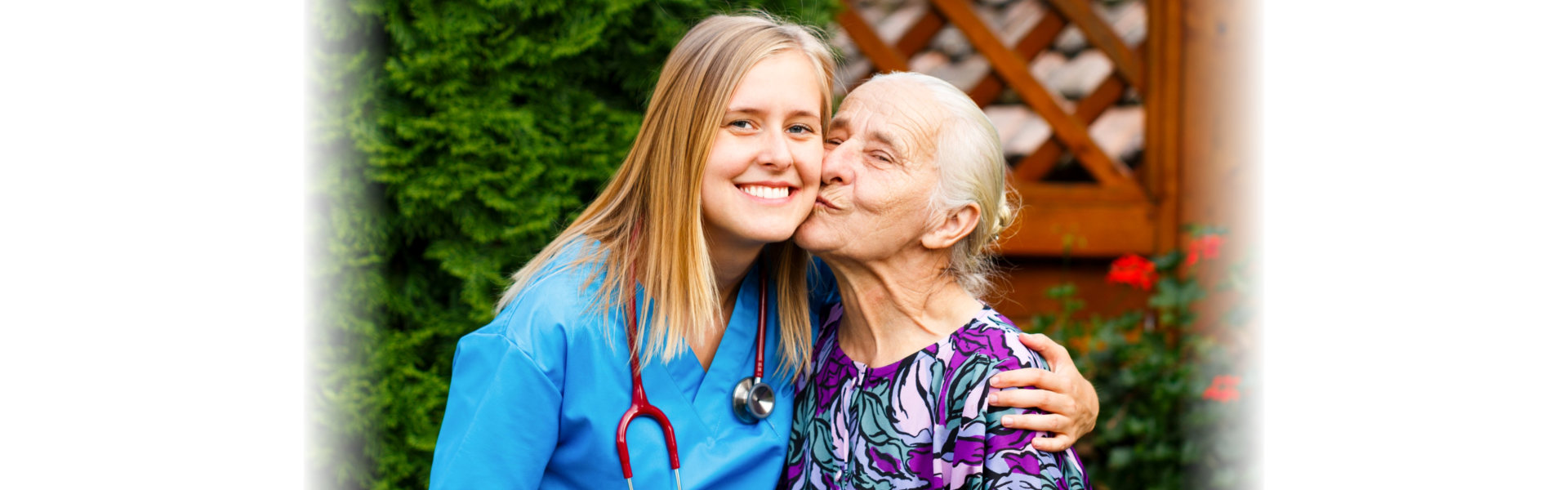 senior woman kissing female nurse in the cheek