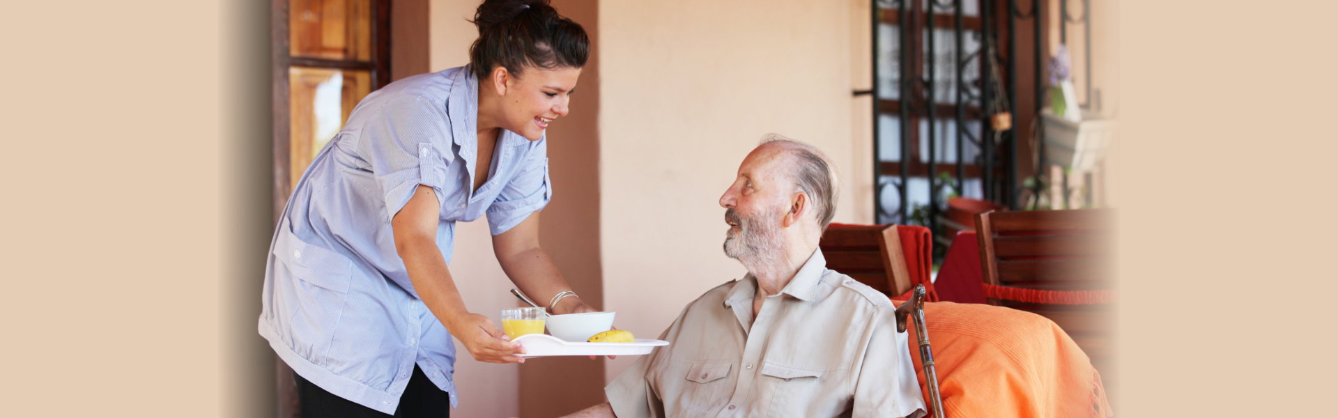 caregiver serving food to senior man