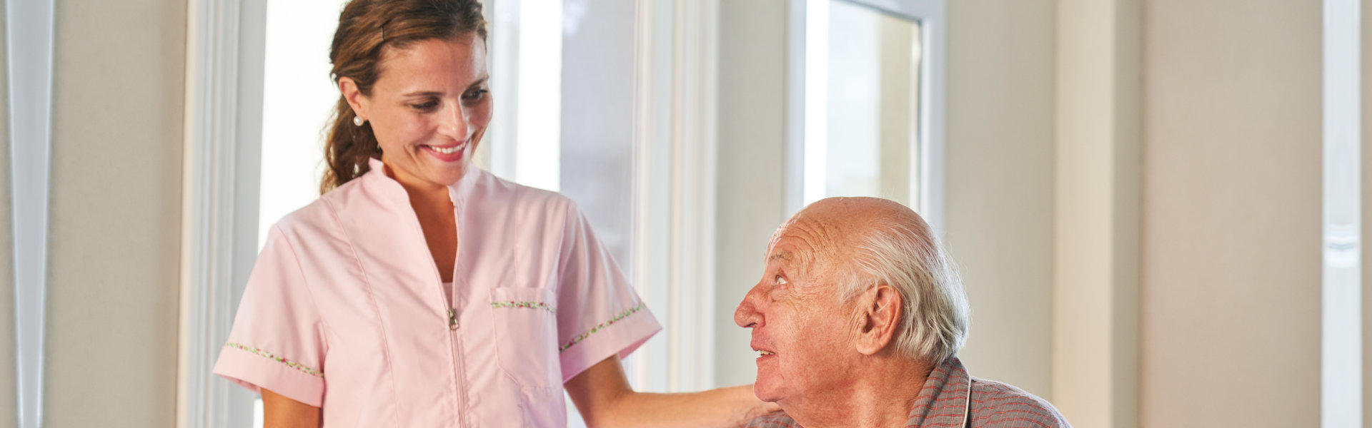 Female caregiver giving assistance to an elderly man