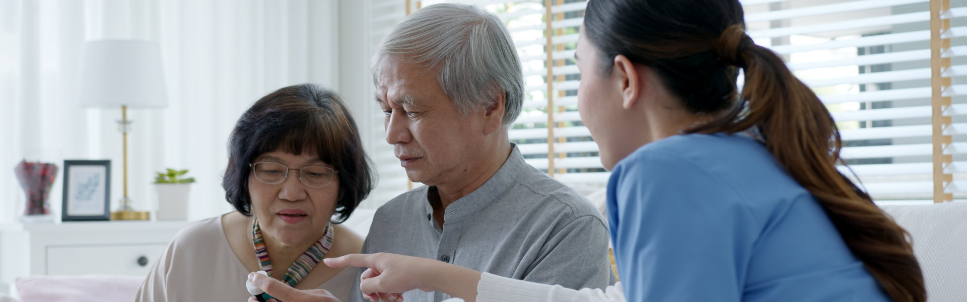 caregiver explain medication to senior couple