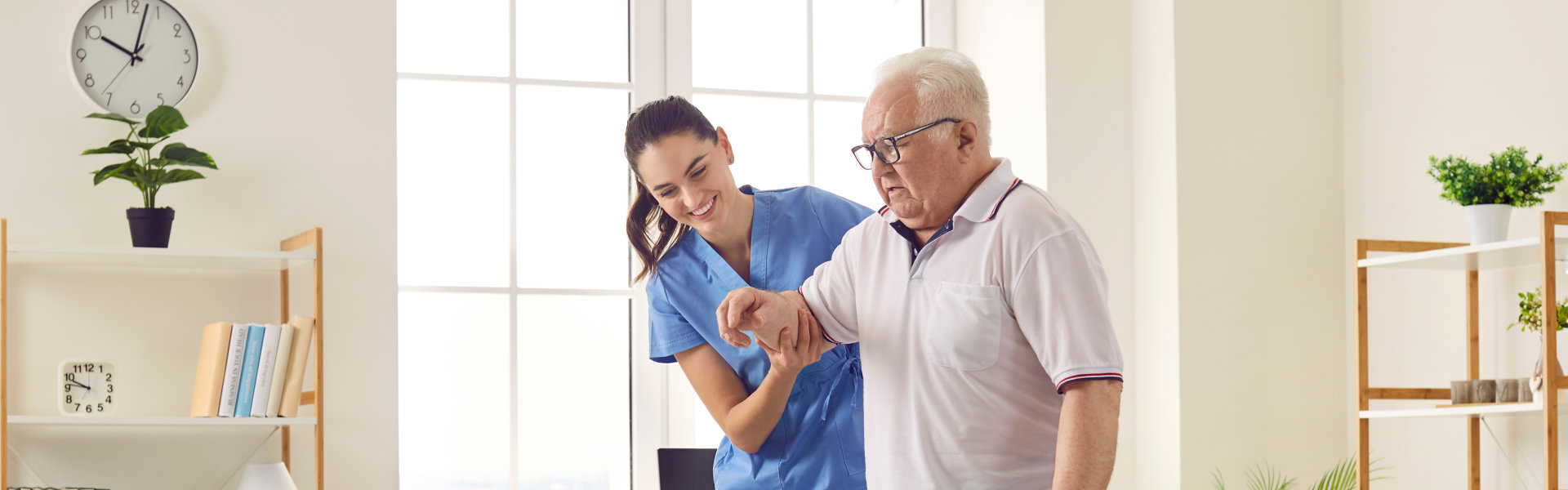 Smiling caregiver helping senior man to stand up