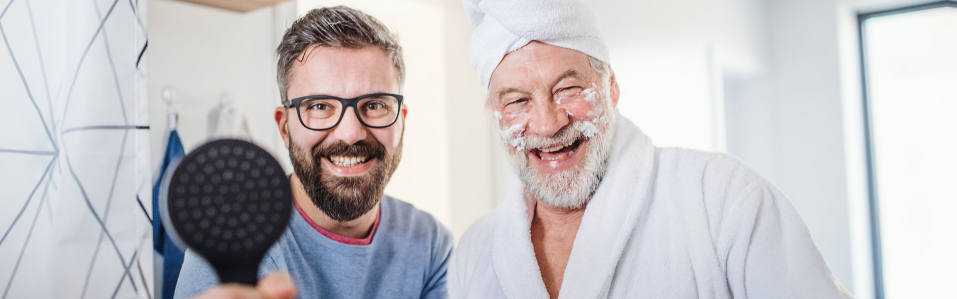 A male caregiver helping an elderly man in his bathing